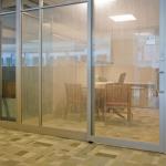 A sliding narrow-stile aluminum & glass door is installed on the office exterior wall.
