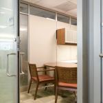 A combination of full-height glazing and solid surface/glass panels between offices.