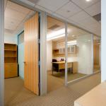 An aluminum spacer is used to cover the end of the GWB office dividing wall and to join adjacent door frame panels.