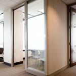 A sliding aluminum door works well in this challenging condition, and inserts of opague & clear glass provide privacy for the office worker while allowing natural light into the interior space.