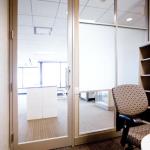 This office features a narrow-stile aluminum and glass door.  The panels feature horizontal aluminum muntins with inserts of clear and opaque glass for privacy, while taking advantage of nearby natural light.