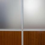 Aluminum stiles form a sleek intersecton between two panels with glass and wood inserts.