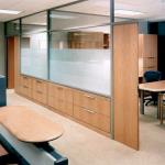 The framing for the glazing was built to accomodate custom millwork cabinets and hinged doors with matching side panels.