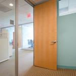 A full-height door uses quartered maple veneer to match the furniture.
