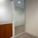 A frameless glass door is used for a conference room, along with a "Power Spacer" for a lighting device.