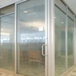This narrow-stile aluminum sliding door is installed on the office exterior.  In addition to the offset tube pull, a separate locking cylinder is provided.